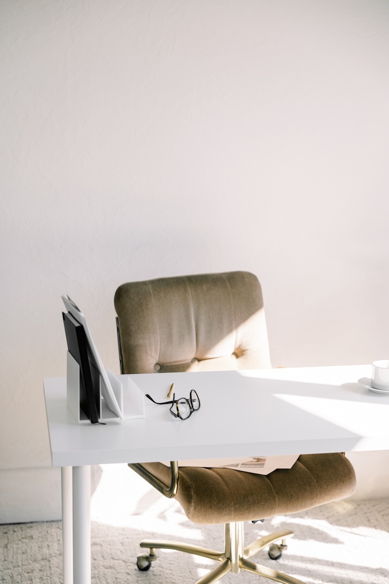 Minimal office workspace with white desk and green chair
